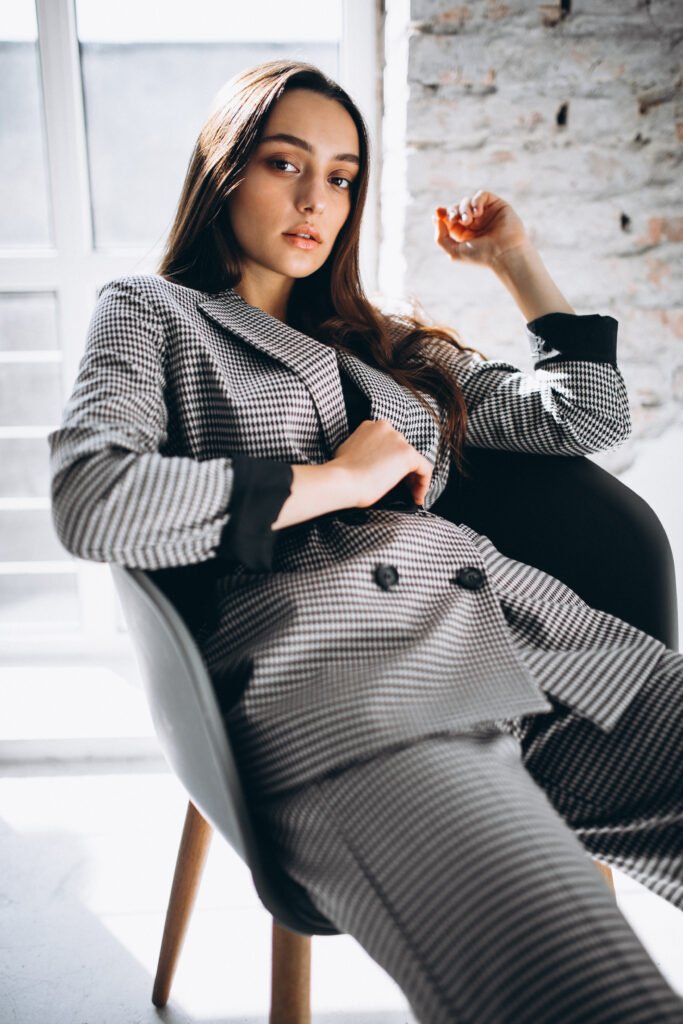 Beautiful woman in a business suit sitting in chair in studio